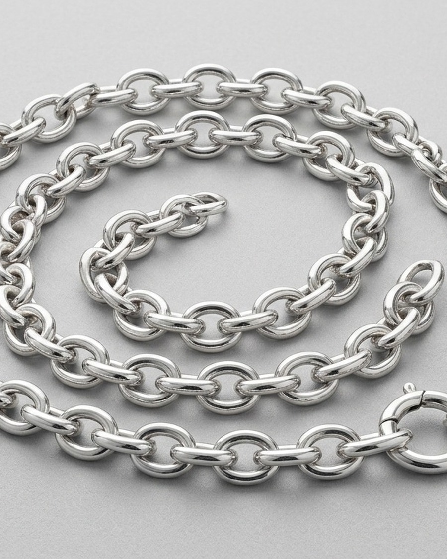 Orbit Chain Necklace — chunky sterling silver cable-chain necklace coiled on a neutral surface